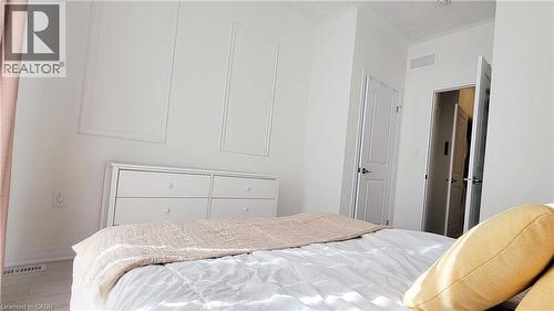 Bright interior space featuring light-colored walls and flooring, accented by wainscoting detailing - 142 Foamflower Place Unit# 12, Waterloo, ON - Indoor Photo Showing Bedroom
