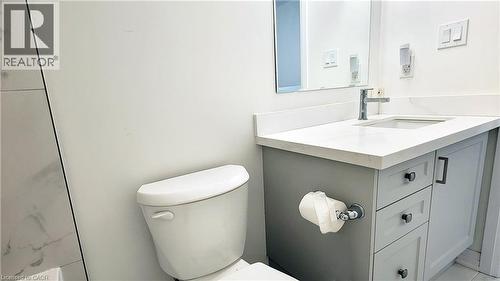 Gray vanity with an integrated sink and light-toned countertop, featuring a chrome faucet - 142 Foamflower Place Unit# 12, Waterloo, ON - Indoor Photo Showing Bathroom