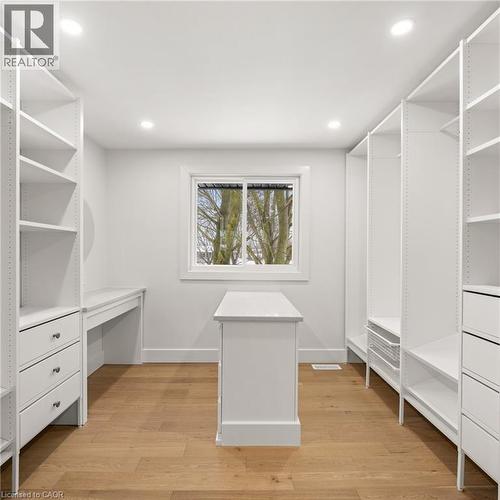 Bright, organized space featuring extensive built-in white shelving, recessed lighting, and wood-finish flooring - 361 Coleridge Place, Waterloo, ON - Indoor