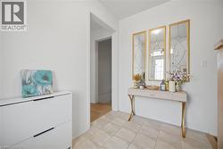 Tiled entryway featuring a decorative console table and a set of three framed mirrors - 