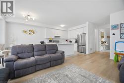 Open-concept living space featuring wood-finish flooring throughout - 