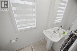 Pedestal sink with chrome faucet, large wall-mounted mirror, and a window with horizontal blinds - 