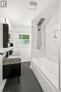 Modern bathroom featuring a jetted tub, a multi-function shower panel, and a wall-mounted vanity with an integrated sink - 