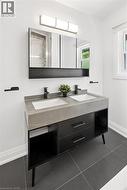 Dual-sink vanity with a light gray countertop, matte black faucets, and dark gray floor tiles - 