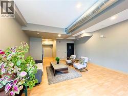 Spacious common area featuring light wood-finish flooring, recessed lighting, and exposed ductwork - 