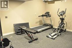 Dedicated fitness area featuring durable speckled rubber flooring and neutral painted walls - 