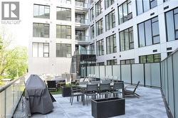 Spacious outdoor terrace with concrete paver flooring, glass panel railing, and frosted privacy screens - 