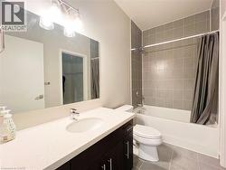 Contemporary bathroom featuring a dark wood-finish vanity with a white countertop and undermount sink - 