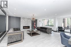 Spacious room featuring large format tile flooring, a modern fireplace with a herringbone tile surround, recessed lighting, and expansive windows - 