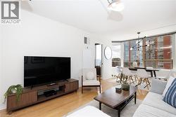 Open-concept living space with wood-finish flooring - 