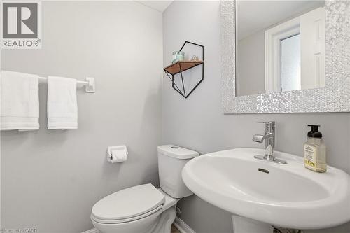 Pedestal sink with chrome faucet, complemented by a mosaic-tiled mirror - 2089 Broadleaf Crescent, Burlington, ON 