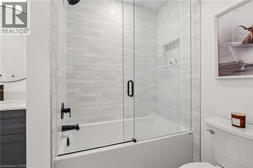 Shower-over-tub combination with white subway tile surround, clear glass enclosure, and matte black fixtures - 2089 Broadleaf Crescent, Burlington, ON 