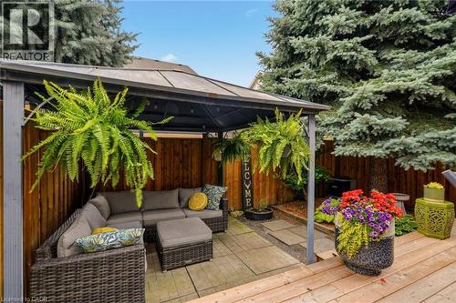 Outdoor covered patio featuring paver flooring, a wood privacy fence, and string lighting - 2089 Broadleaf Crescent, Burlington, ON 