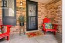 Brick exterior featuring dark-framed windows and a complementary dark-framed storm door - 2089 Broadleaf Crescent, Burlington, ON 