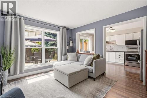 Living area featuring dark wood-finish flooring and a large window - 2089 Broadleaf Crescent, Burlington, ON 