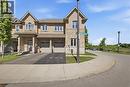 End unit townhome featuring a stucco and stone facade, arched windows, and a two-car garage - 104 Sonoma Valley Crescent, Hamilton, ON  - Outdoor With Facade 
