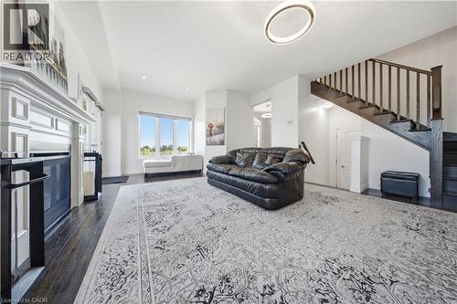 Spacious room featuring wood-finish flooring and a white decorative fireplace - 104 Sonoma Valley Crescent, Hamilton, ON - Indoor