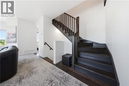 Dark wood-finish staircase with matching handrail and spindles - 104 Sonoma Valley Crescent, Hamilton, ON - Indoor Photo Showing Other Room