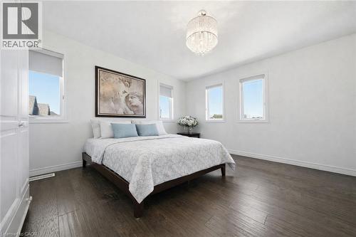 Spacious room featuring dark wood-finish flooring and a multi-pane window - 104 Sonoma Valley Crescent, Hamilton, ON - Indoor Photo Showing Bedroom