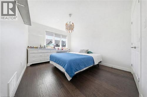 Spacious room with dark wood-finish flooring, white baseboards, and a vaulted ceiling - 104 Sonoma Valley Crescent, Hamilton, ON - Indoor Photo Showing Bedroom
