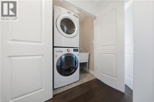 Dedicated laundry area featuring a stackable washer and dryer, utility sink, and tiled flooring - 104 Sonoma Valley Crescent, Hamilton, ON - Indoor Photo Showing Laundry Room