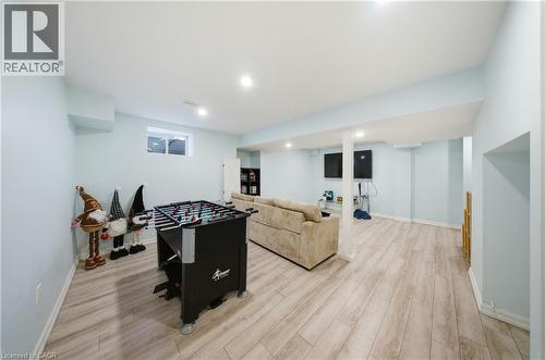 Spacious finished basement featuring recessed lighting, a window, wood-finish flooring, light blue wall paint, and white trim - 104 Sonoma Valley Crescent, Hamilton, ON - Indoor