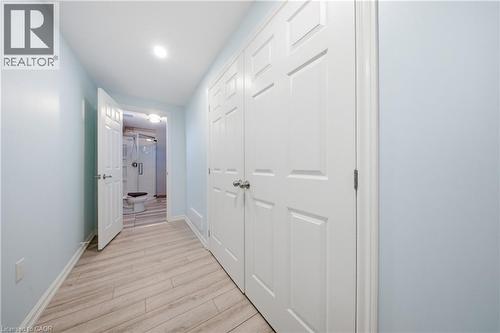 Hallway featuring wood-finish flooring and light blue walls - 104 Sonoma Valley Crescent, Hamilton, ON - Indoor Photo Showing Other Room