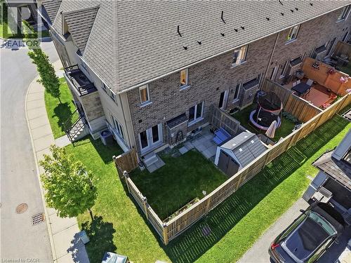 Private fenced backyard with a manicured lawn, concrete patio, and garden shed - 104 Sonoma Valley Crescent, Hamilton, ON - Outdoor