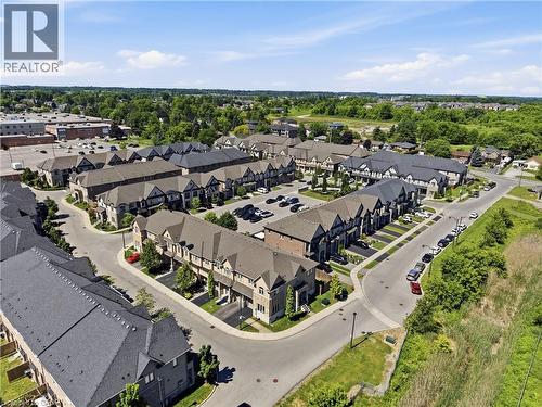 Aerial perspective of a residential development featuring rows of townhomes with varied facade designs and individual driveways - 104 Sonoma Valley Crescent, Hamilton, ON - Outdoor With View
