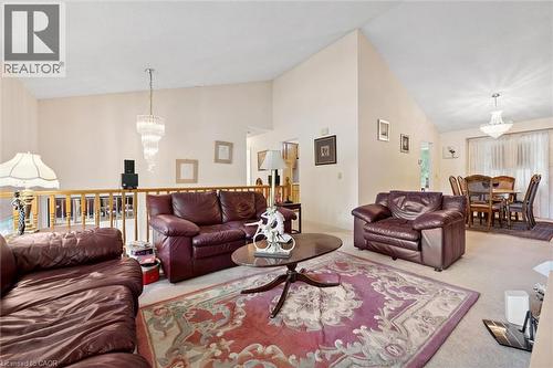 Vaulted ceilings define this living area, featuring a tiered chandelier and light-colored carpeting - 176 Sandford Fleming Drive, Waterloo, ON - Indoor Photo Showing Living Room
