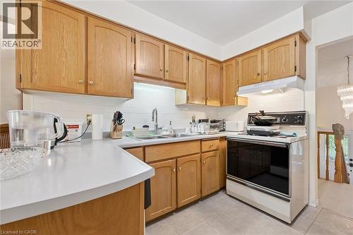 Kitchen featuring wood cabinetry, white countertops, tile backsplash, and tile flooring - 176 Sandford Fleming Drive, Waterloo, ON - Indoor Photo Showing Kitchen With Double Sink