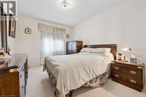 Carpeted bedroom featuring a window with sheer and fabric treatments, a ceiling-mounted light fixture, and light-toned walls - 176 Sandford Fleming Drive, Waterloo, ON - Indoor Photo Showing Bedroom
