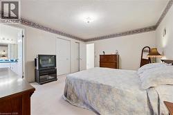Carpeted bedroom with a flat white ceiling, white walls, and decorative wallpaper border - 