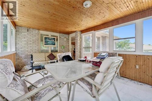 Sunroom featuring a wood-paneled ceiling, exposed brick wall, and multiple windows - 176 Sandford Fleming Drive, Waterloo, ON - Outdoor With Deck Patio Veranda With Exterior