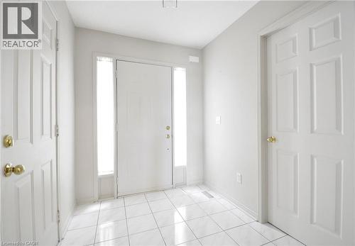 Entryway featuring white tile flooring and a solid white door with sidelight windows - 95 Drinkwater Drive, Cambridge, ON - Indoor Photo Showing Other Room