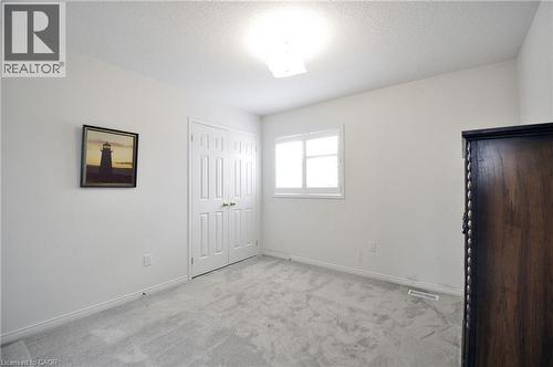Bright interior space featuring light-colored walls and grey carpeting - 95 Drinkwater Drive, Cambridge, ON - Indoor Photo Showing Other Room
