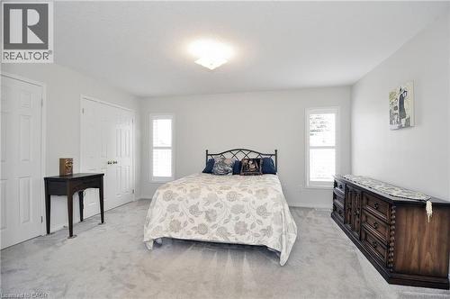 Bedroom featuring light gray carpeting, neutral wall color, two double-door closets, and two vertical windows with louvered blinds - 95 Drinkwater Drive, Cambridge, ON - Indoor Photo Showing Bedroom