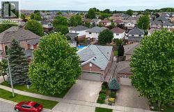 Brick exterior residence featuring a two-car garage, concrete driveway, and mature landscaping - 