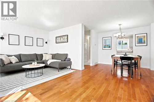 Bright open-concept living area featuring wood-finish flooring, white walls, and recessed lighting - 175 Siebert Avenue Unit# 9, Kitchener, ON 