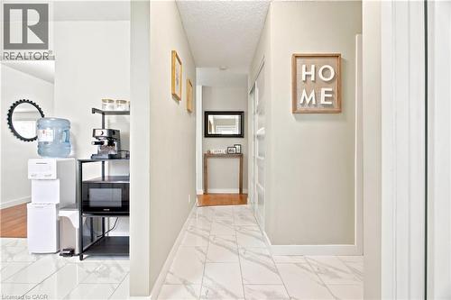 Tiled hallway featuring light-toned walls and crown molding - 175 Siebert Avenue Unit# 9, Kitchener, ON 
