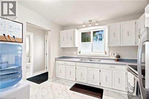 Kitchen featuring white cabinetry, a double basin sink, and laminate countertops - 175 Siebert Avenue Unit# 9, Kitchener, ON 