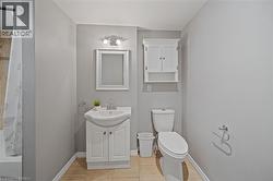 Bathroom featuring a white vanity with integrated sink, chrome faucet, and framed mirror - 