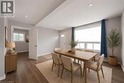 Open-concept dining area featuring wood-finish flooring, recessed lighting, and a large multi-pane window - 