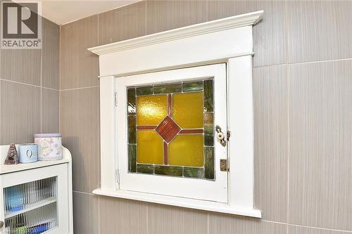 Built-in cabinet with stained glass door and decorative white trim - 56 Barons Avenue N, Hamilton, ON 