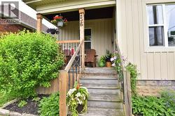 Inviting front porch featuring natural wood steps and railings, supported by square wooden columns - 