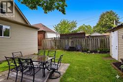 Spacious backyard featuring a paver patio area, a detached shed, a privacy fence, and a manicured lawn - 