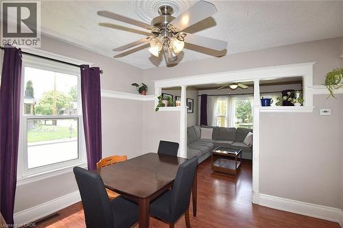 Dining area with wood-finish flooring, a ceiling fan with light fixture, and a window featuring white trim - 56 Barons Avenue N, Hamilton, ON 