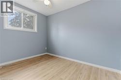 Room featuring light blue walls, wood-finish flooring, and white trim - 