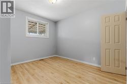 Spacious room with wood-finish flooring, light gray walls, and white trim - 