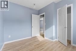 Interior room featuring light blue walls, white trim, and wood-finish flooring - 